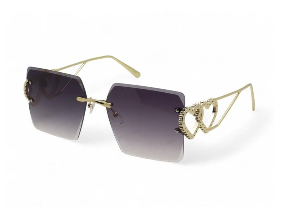 A pair of gold-colored sunglasses with a decorative pattern on the templets a
